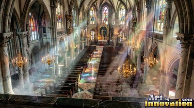 In a cathedral, sunlight cuts through haze over rows of empty wooden pews