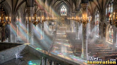 Sunlight pours into a cathedral with stone pillars and wooden pews