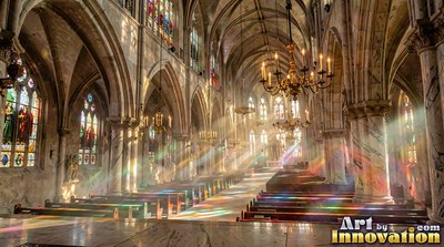 A cathedral with stone walls fills with sunbeams that scatter rainbow light over rows of wooden pews