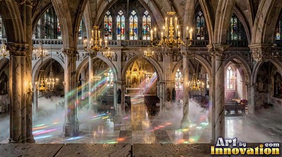 Filling with light, a cathedral holds drifting mist under chandeliers