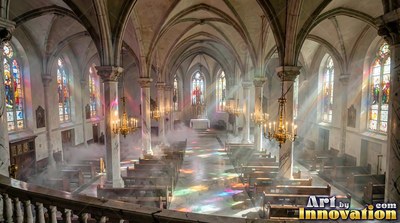 Cathedral interior with light rays across foggy pews