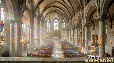 Seen from high above, colored sunlight filters through a tall stone cathedral aisle