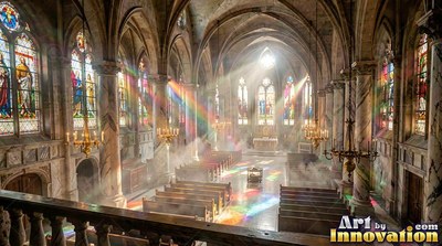 Lighting up empty wooden pews, colorful sunbeams pour into a cathedral with stone walls