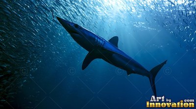 A blue shark swims upward past a school of fish in deep sunlight