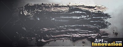 Spread horizontally across a gray surface, thick black paint reflects soft light