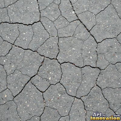 Asphalt pavement marked with oil stains and tire scuffs in medium gray