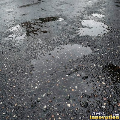 Wet asphalt glistening with small puddles in a greenish gray tone