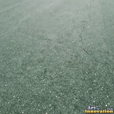 Wet asphalt glistening with small puddles in a greenish gray tone