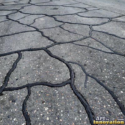 Worn asphalt with faded fragments of painted road lines