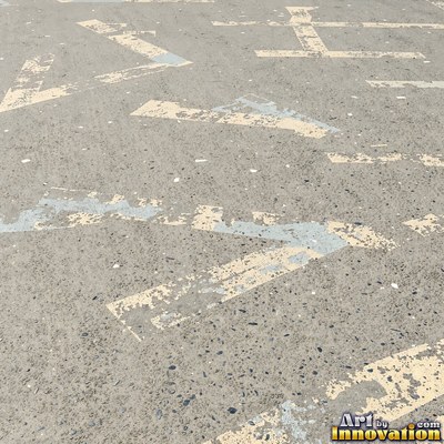 Wet asphalt glistening with small puddles in a greenish gray tone