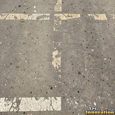 Asphalt pavement marked with oil stains and tire scuffs in medium gray