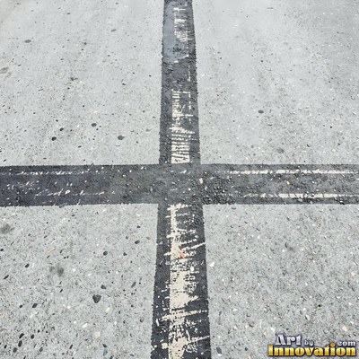 Worn asphalt with faded fragments of painted road lines