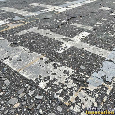Worn asphalt with faded fragments of painted road lines