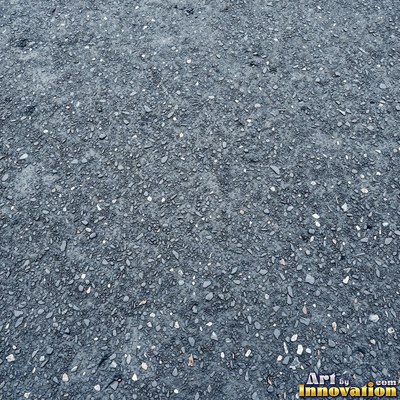 Asphalt pavement marked with oil stains and tire scuffs in medium gray
