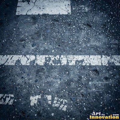 Worn asphalt with faded fragments of painted road lines