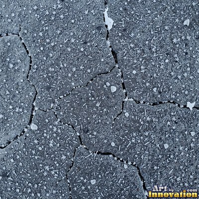 Wet asphalt glistening with small puddles in a greenish gray tone