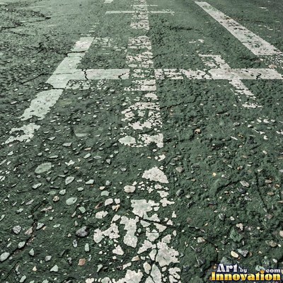 Worn asphalt with faded fragments of painted road lines