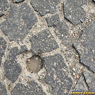 Asphalt pavement marked with oil stains and tire scuffs in medium gray