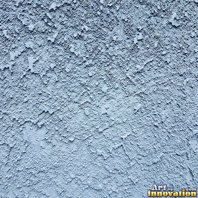 Cracked plaster with fine spidery lines in faded mint green paint