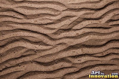 Pink sand marked with small swirls carved by the wind