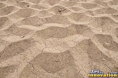 Dry cracked sand crust in rust red clay tones