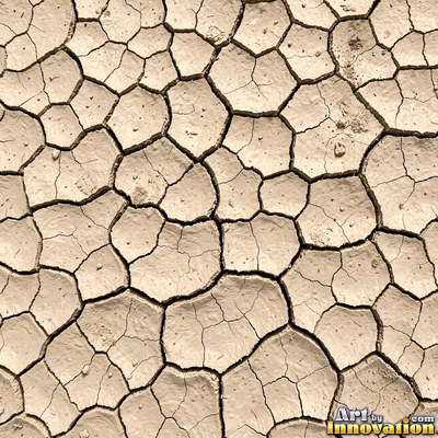 Dry cracked mud broken into polygon shaped plates of clay brown