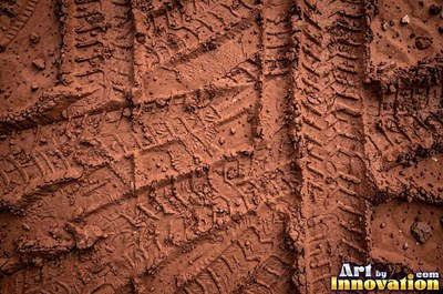 Dry cracked mud broken into polygon shaped plates of clay brown