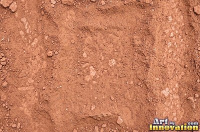 Dry cracked mud broken into polygon shaped plates of clay brown