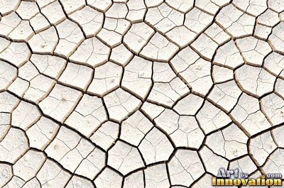 Dry cracked mud broken into polygon shaped plates of clay brown