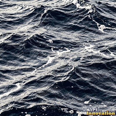 Close wave crest with white foam on inky blue black water