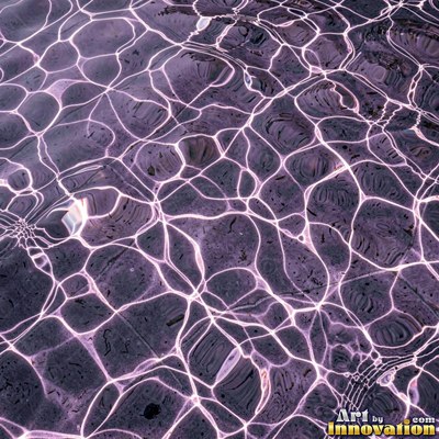 Concentric ripples spreading from a single drop on teal water
