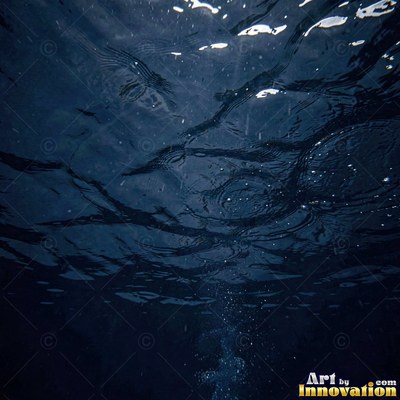 Concentric ripples spreading from a single drop on teal water