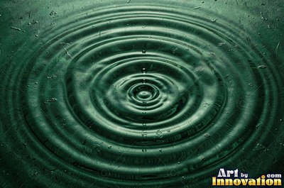 Concentric ripples spreading from a single drop on teal water