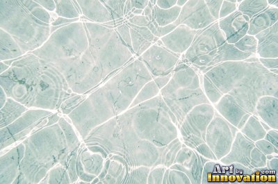 Choppy water surface of many small waves with gold reflections