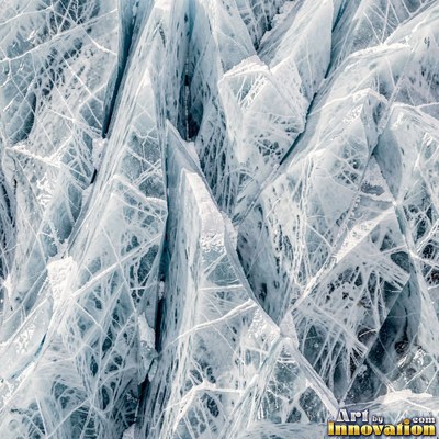 Cracked lake ice with white fracture lines and a honey gold glow