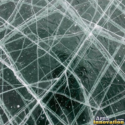 Cracked lake ice with white fracture lines and a honey gold glow