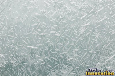 Snowflakes resting on dark sea green ice