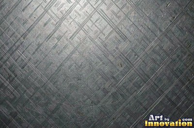 Coarse brushed finish with deep grain lines in dark gunmetal