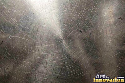 Polished satin chrome with a fine scratch pattern catching the glare