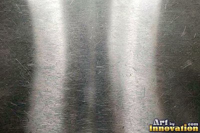 Polished satin chrome with a fine scratch pattern catching the glare