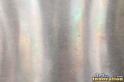 Mirror polished metal reflecting soft abstract gradients of light