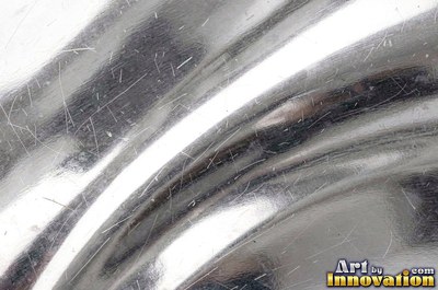 Mirror polished metal reflecting soft abstract gradients of light