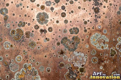 Oxidized copper with a mottled dark surface and bright scratches