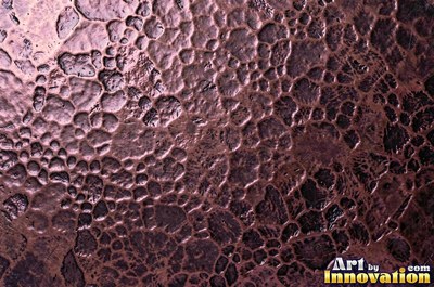 Oxidized copper with a mottled dark surface and bright scratches