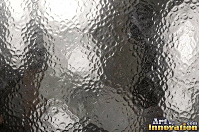 Large shallow hammer marks catching light like ripples on water