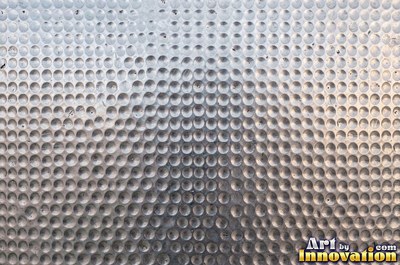 Large shallow hammer marks catching light like ripples on water