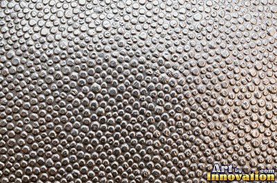 Planished metal with faint flat facets in a regular grid