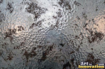 Planished metal with faint flat facets in a regular grid