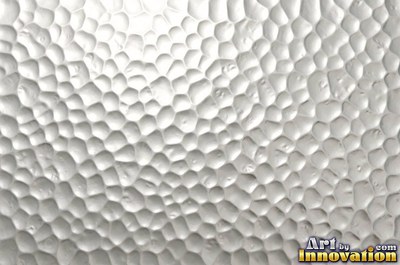 Large shallow hammer marks catching light like ripples on water