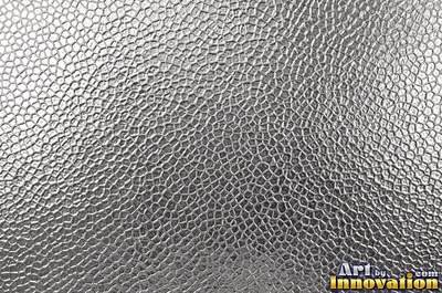 Planished metal with faint flat facets in a regular grid